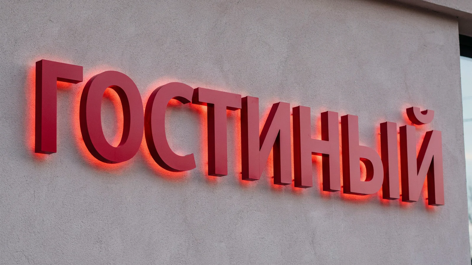 Крупный план вывески магазина: красные объёмные буквы с контражурной подсветкой